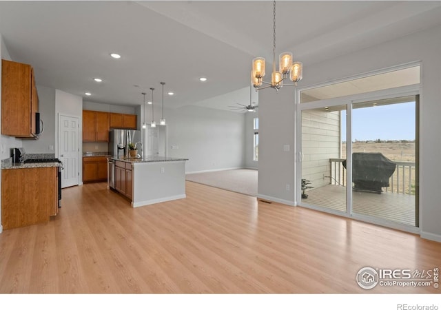 1103 Hornet Dr, Fort Collins, CO 80526 - kitchen with ceiling fan with notable chandelier, brown cabinetry, light wood-type flooring, appliances with stainless steel finishes, and open floor plan
