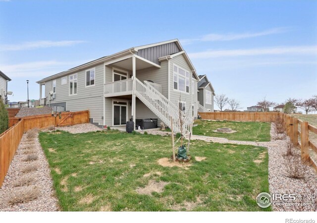 1103 Hornet Dr, Fort Collins, CO 80526 - back of property featuring a yard, a fenced backyard, a fire pit, stairs, and a deck