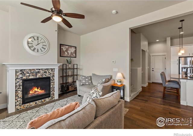 1708 W 50th St, Loveland, CO 80538 - living area with baseboards, a ceiling fan, a fireplace, and dark wood-style floors
