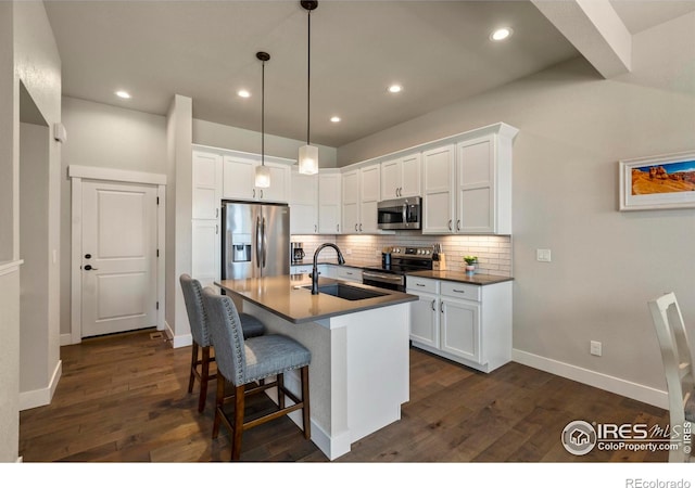 1708 W 50th St, Loveland, CO 80538 - kitchen featuring dark wood-type flooring, tasteful backsplash, white cabinets, appliances with stainless steel finishes, and a sink