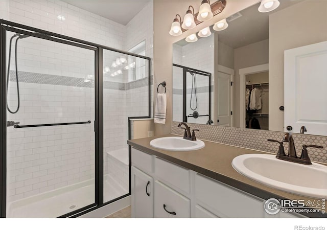 1708 W 50th St, Loveland, CO 80538 - bathroom featuring a spacious closet, double vanity, a sink, and a stall shower