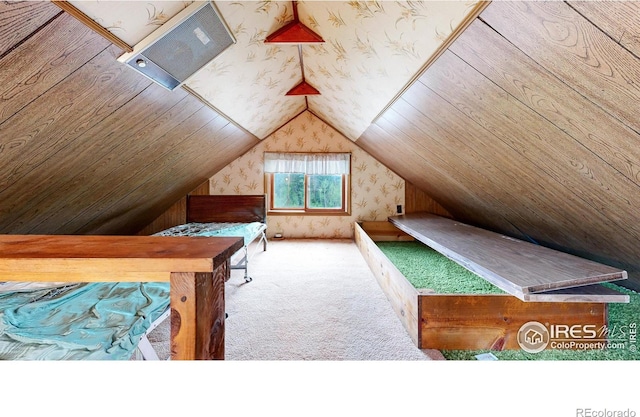 carpeted bedroom with vaulted ceiling and wallpapered walls
