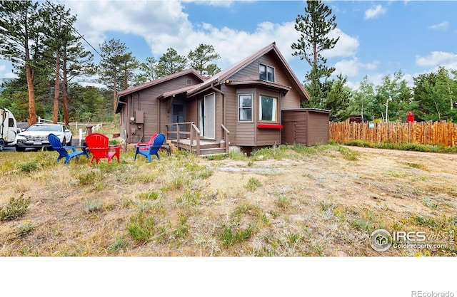 rear view of house featuring fence