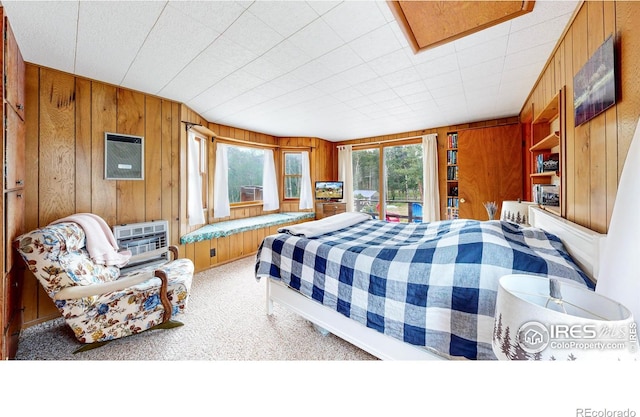 carpeted bedroom featuring wood walls and heating unit