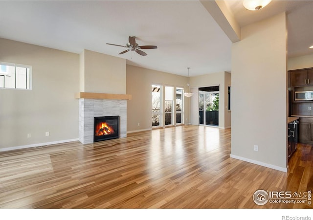 3620 Paonia St, Boulder, CO 80301 - unfurnished living room with baseboards, a ceiling fan, a tile fireplace, and light wood-style floors