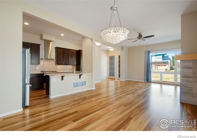 3620 Paonia St, Boulder, CO 80301 - unfurnished living room featuring visible vents, baseboards, light wood-style floors, recessed lighting, and ceiling fan with notable chandelier