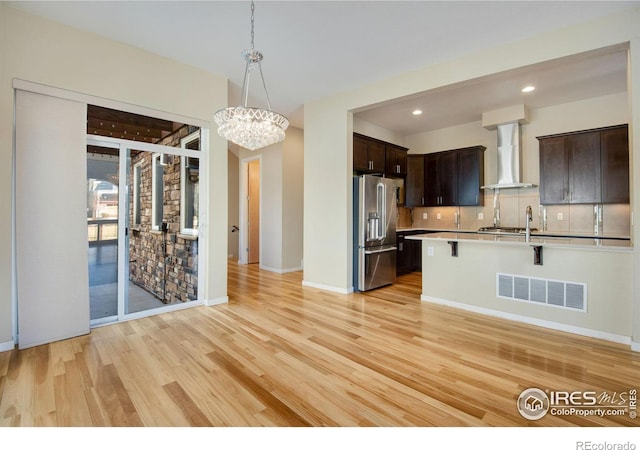 3620 Paonia St, Boulder, CO 80301 - kitchen with dark brown cabinetry, high end fridge, wall chimney range hood, light countertops, and visible vents