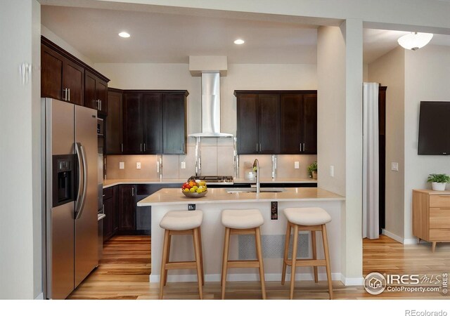3620 Paonia St, Boulder, CO 80301 - kitchen featuring a breakfast bar, stainless steel fridge, wall chimney range hood, light countertops, and a sink