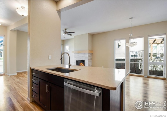 3620 Paonia St, Boulder, CO 80301 - kitchen featuring a sink, open floor plan, light wood-style floors, stainless steel dishwasher, and a glass covered fireplace