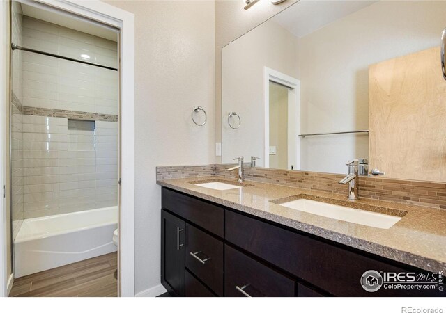 3620 Paonia St, Boulder, CO 80301 - full bath with wood finished floors, double vanity, a sink, and backsplash
