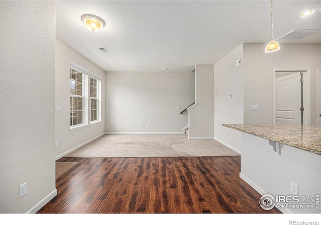 interior space with stairs, visible vents, baseboards, and wood finished floors