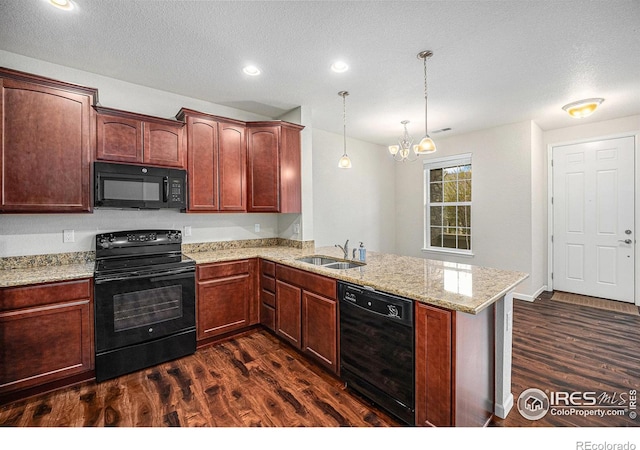 kitchen featuring an inviting chandelier, a sink, a peninsula, black appliances, and dark wood-type flooring