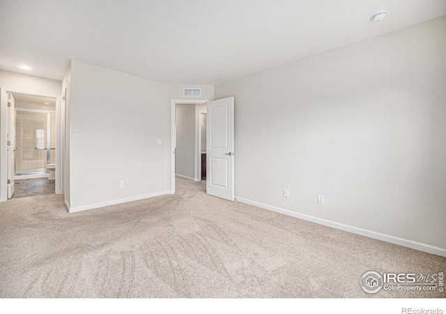 unfurnished bedroom with carpet flooring, baseboards, and visible vents