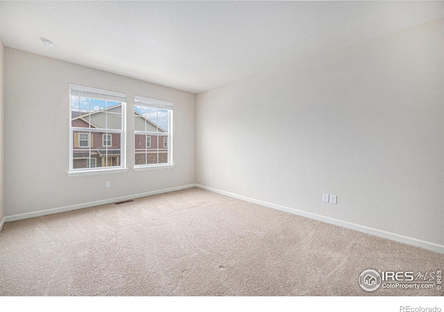 carpeted empty room with visible vents and baseboards