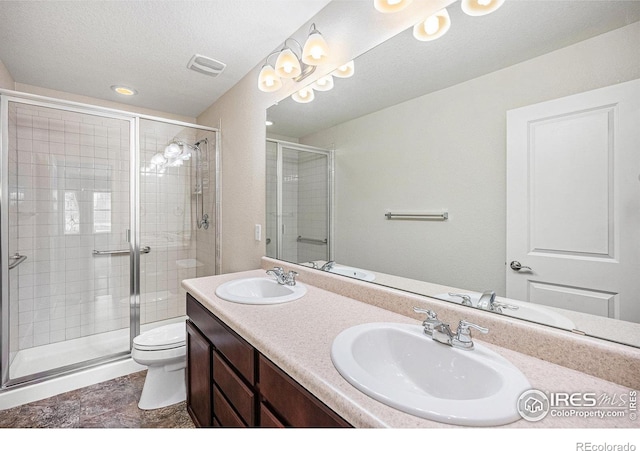 bathroom featuring a stall shower, a sink, visible vents, and a textured ceiling