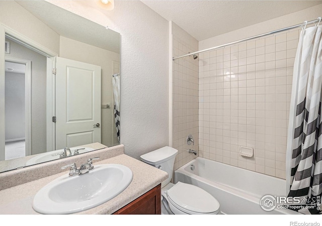 bathroom with a textured ceiling, vanity, toilet, shower / tub combo with curtain, and a textured wall