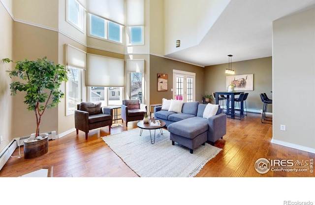 2025 Mathews St Unit 3, Fort Collins, CO 80525 - living room with wood-type flooring, baseboards, a high ceiling, and a baseboard radiator