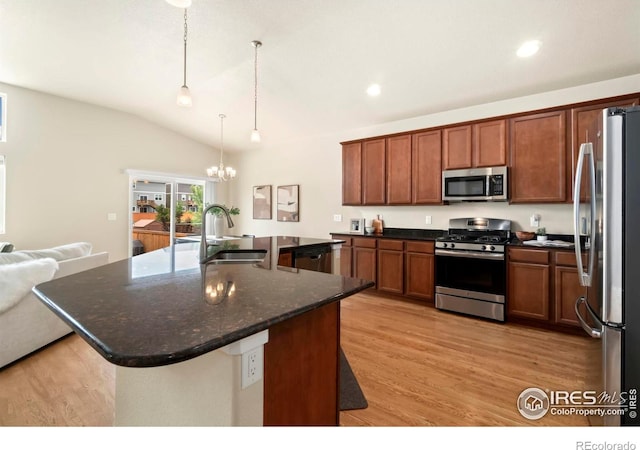 kitchen featuring an inviting chandelier, a sink, light wood-style floors, vaulted ceiling, and stainless steel appliances