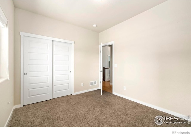 unfurnished bedroom featuring a closet, baseboards, visible vents, and carpet floors