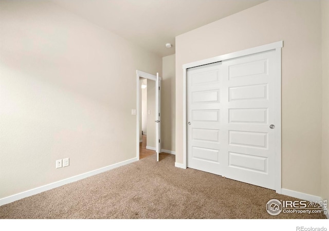 unfurnished bedroom featuring a closet, carpet flooring, and baseboards