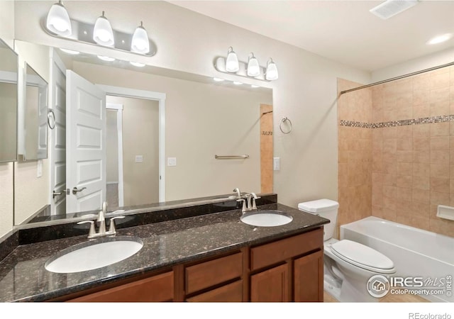 full bathroom featuring double vanity,  shower combination, a sink, and toilet
