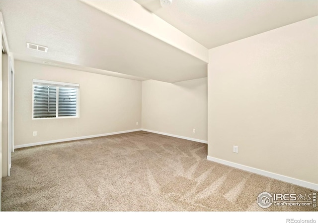 additional living space with carpet floors, baseboards, and visible vents