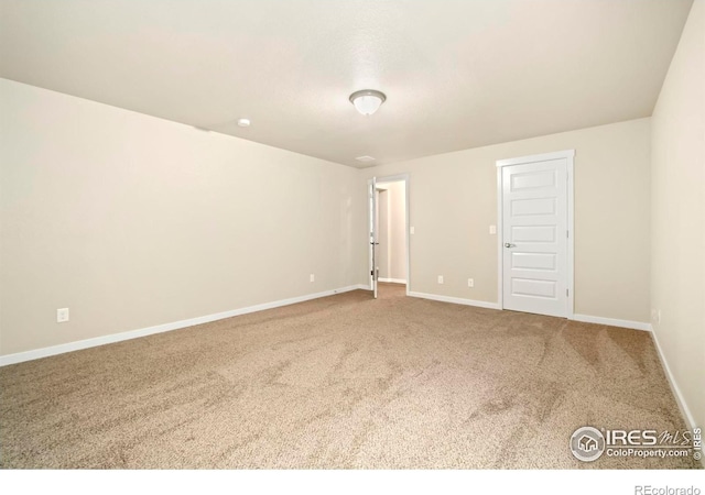 empty room featuring carpet flooring and baseboards