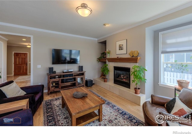 4921 Fountain St, Boulder, CO 80304 - living area featuring ornamental molding, wood finished floors, a tiled fireplace, and baseboards