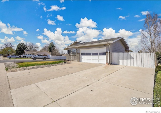 3735 W 8th St, Greeley, CO 80634 - view of home's exterior with fence, a garage, and driveway