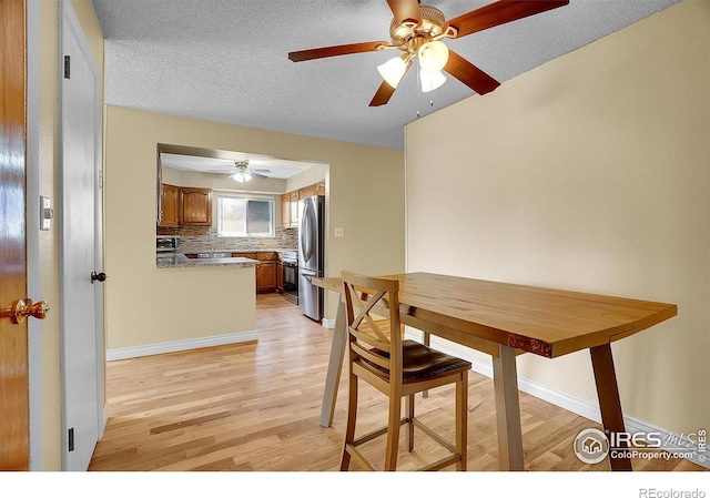 3735 W 8th St, Greeley, CO 80634 - dining area with baseboards, a ceiling fan, light wood-style floors, and a textured ceiling