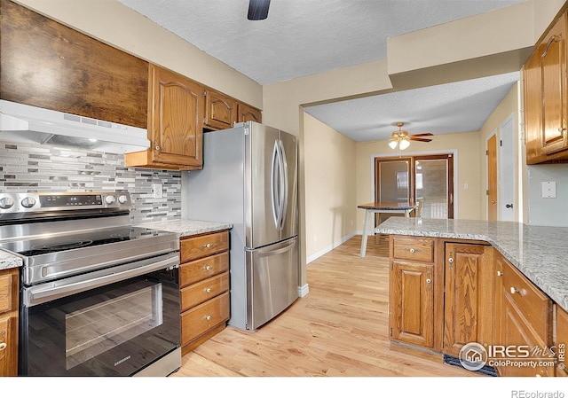 3735 W 8th St, Greeley, CO 80634 - kitchen featuring ceiling fan, brown cabinetry, light wood-type flooring, under cabinet range hood, and stainless steel appliances