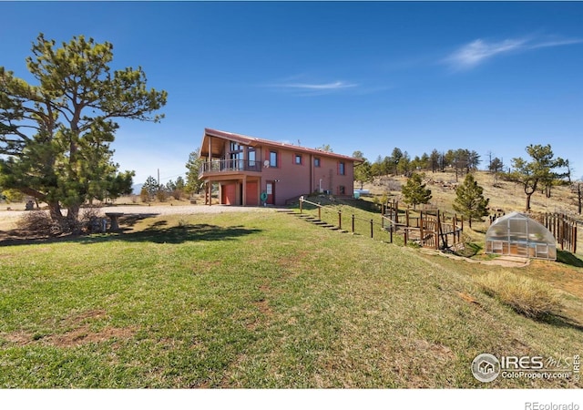 13236 Otter Rd, Loveland, CO 80538 - view of yard featuring a greenhouse, an outbuilding, and a deck
