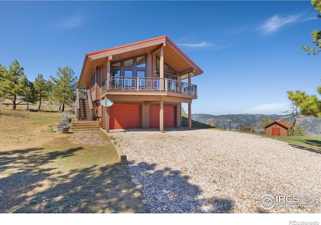 13236 Otter Rd, Loveland, CO 80538 - view of front of house featuring stairs, a mountain view, gravel driveway, and a garage