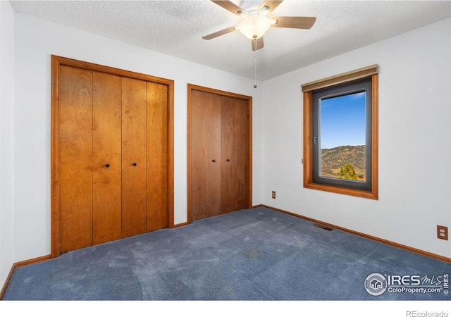 13236 Otter Rd, Loveland, CO 80538 - unfurnished bedroom with two closets, carpet flooring, baseboards, a textured ceiling, and a ceiling fan