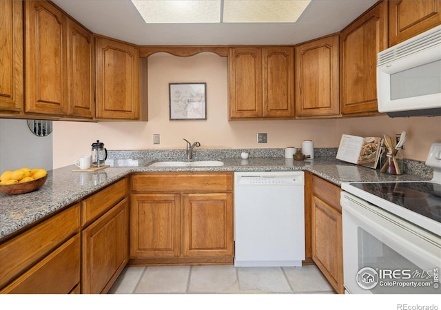 2610 Heidelberg Dr, Boulder, CO 80305 - kitchen featuring a sink, white appliances, dark stone countertops, and brown cabinets