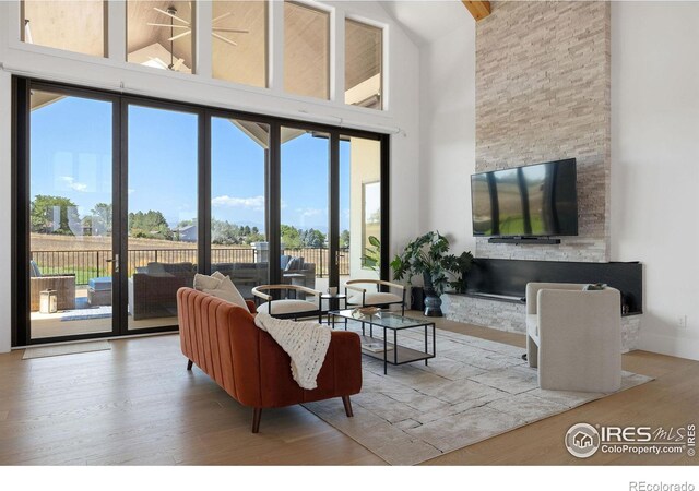 living room with a towering ceiling and wood finished floors