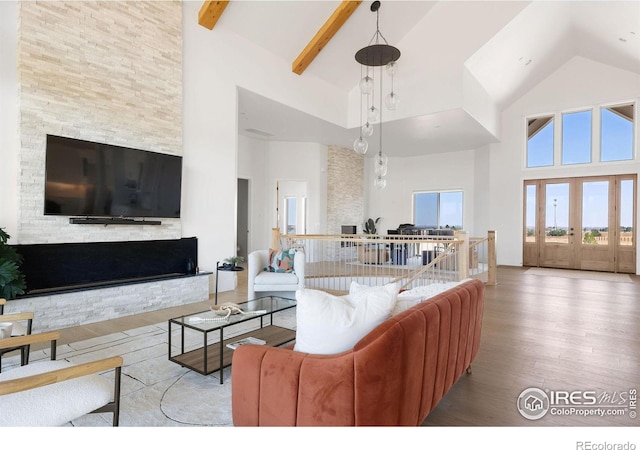 living area featuring wood finished floors, high vaulted ceiling, and beamed ceiling