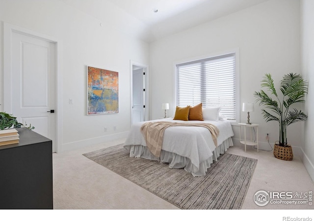 bedroom featuring light colored carpet and baseboards