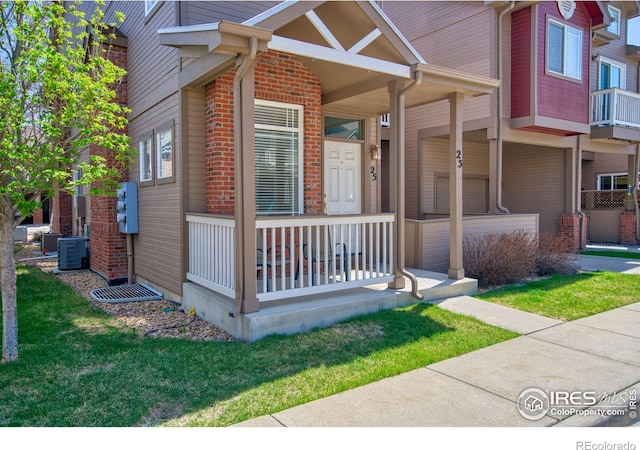 835 Kane Dr Unit 25, Longmont, CO 80501 - entrance to property featuring brick siding, a porch, central AC unit, and a lawn