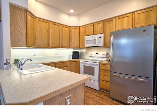 835 Kane Dr Unit 25, Longmont, CO 80501 - kitchen with a sink, light countertops, white appliances, a peninsula, and brown cabinetry