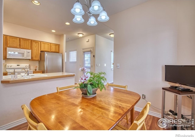 835 Kane Dr Unit 25, Longmont, CO 80501 - dining room with recessed lighting, baseboards, an inviting chandelier, and wood finished floors