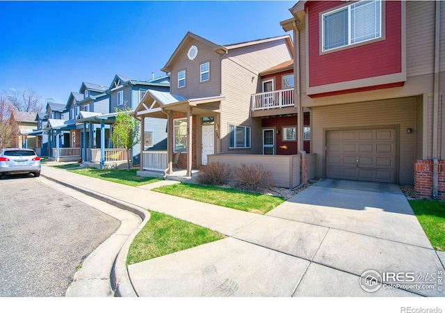 835 Kane Dr Unit 25, Longmont, CO 80501 - townhome / multi-family property with concrete driveway, a residential view, an attached garage, and covered porch
