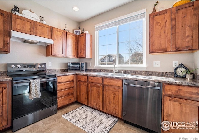 2118 74th Avenue Ct, Greeley, CO 80634 - kitchen with a sink, appliances with stainless steel finishes, dark countertops, under cabinet range hood, and brown cabinetry