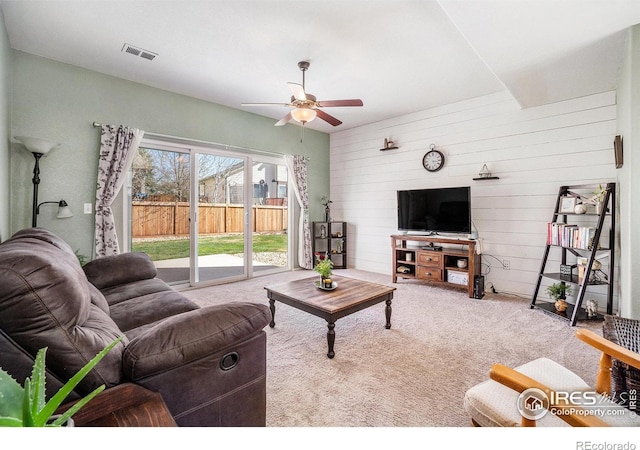 2118 74th Avenue Ct, Greeley, CO 80634 - carpeted living area featuring wooden walls, a ceiling fan, and visible vents