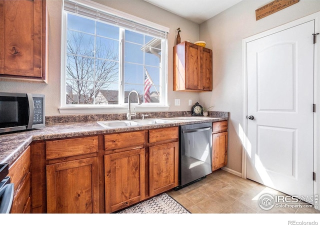 2118 74th Avenue Ct, Greeley, CO 80634 - kitchen featuring a sink, appliances with stainless steel finishes, dark countertops, and brown cabinets