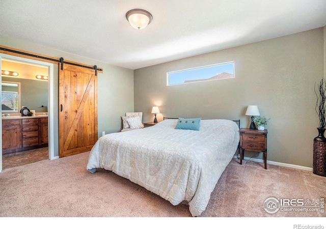 2118 74th Avenue Ct, Greeley, CO 80634 - bedroom with ensuite bath, baseboards, a barn door, and carpet floors