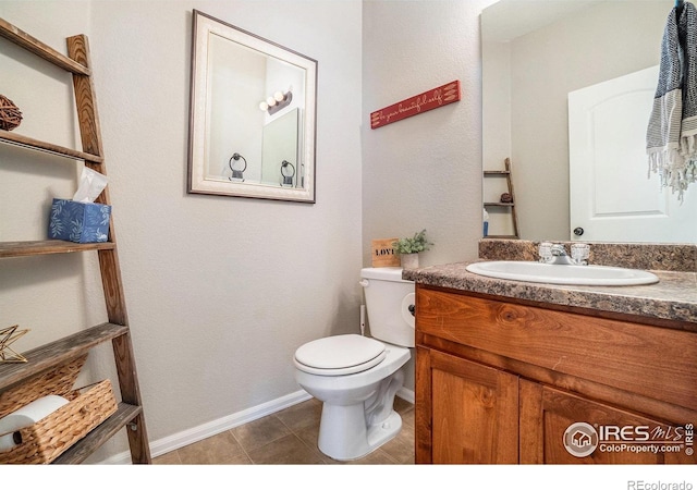 2118 74th Avenue Ct, Greeley, CO 80634 - bathroom with tile patterned floors, toilet, vanity, and baseboards
