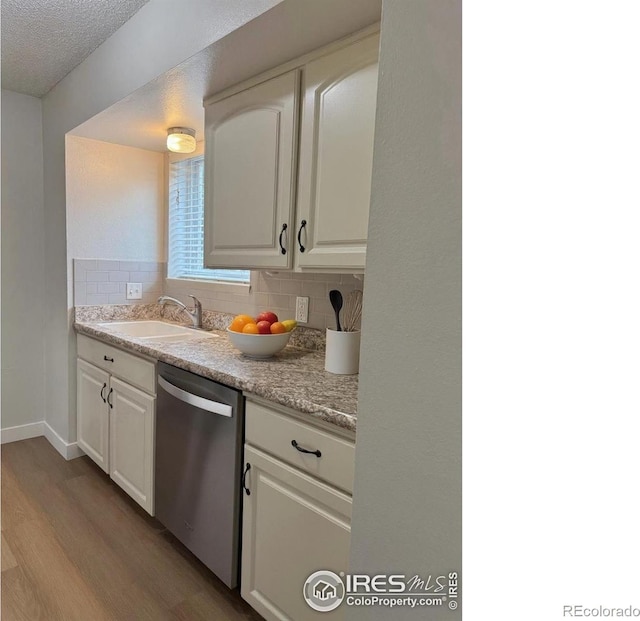 1616 Longbow Ct, Lafayette, CO 80026 - kitchen featuring dishwasher, light wood-type flooring, backsplash, white cabinets, and light countertops