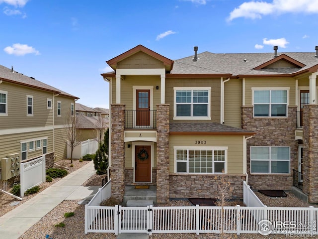 3903 Le Fever Dr Unit A, Fort Collins, CO 80528 - view of front of house with stone siding, a gate, and a fenced front yard