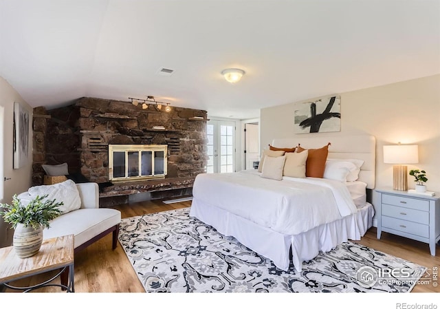 3786 Eldorado Springs Dr, Boulder, CO 80303 - bedroom featuring visible vents, wood finished floors, vaulted ceiling, and a fireplace